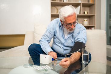 Hypertension problem in senior age. Old man measuring...