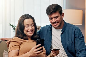 Smile, couple and phone with credit card at house for...