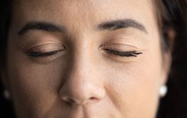 Closed eyes of young Latin woman with permanent eyelashes