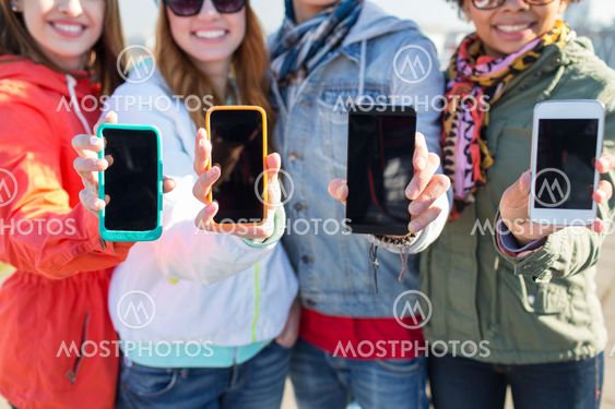close up of friends showing smartphone screens