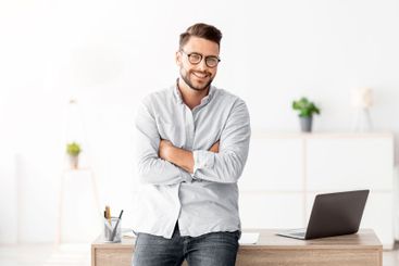 Successful freelancer man standing at desk at home...