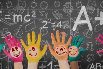 Composite image of hands with colourful smiley faces