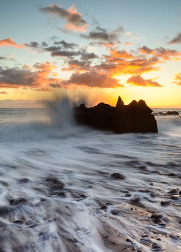 Sunset waves crashing against coastal rocks in Madeira...