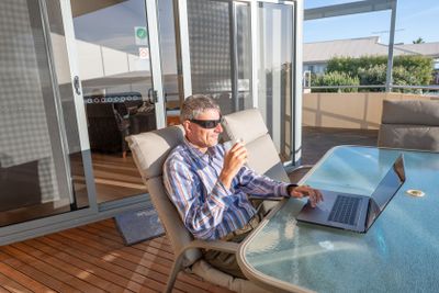 Business mani with modern laptop on a terrace table with...