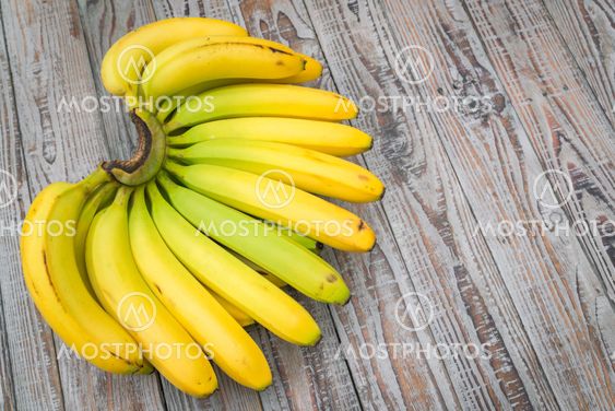 Fresh bananas on wooden table .