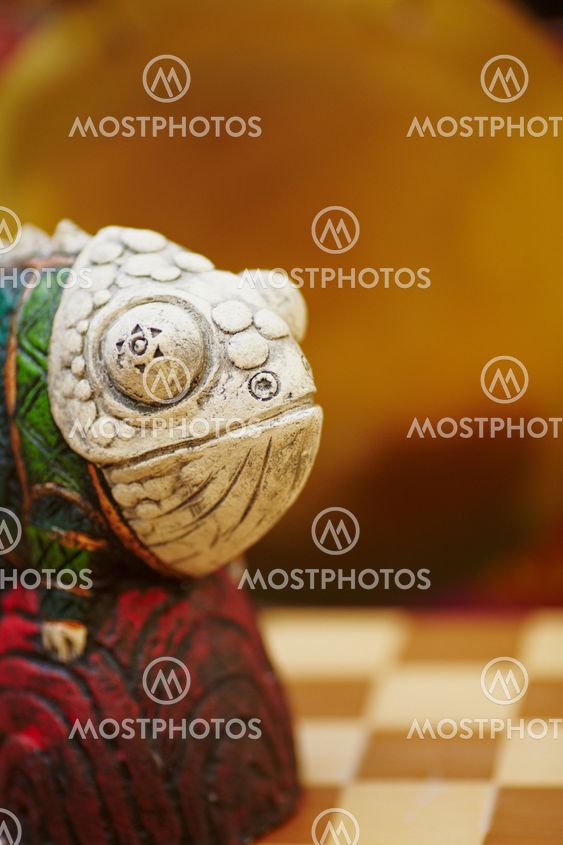 Figurine of chameleon on a chess-board.