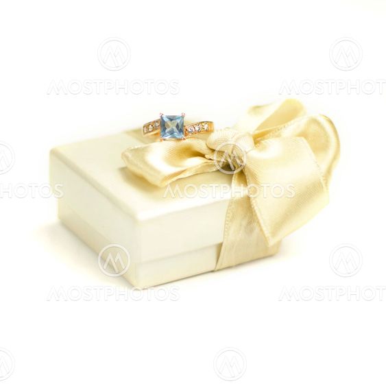 Closeup of gift box and ring on a white background