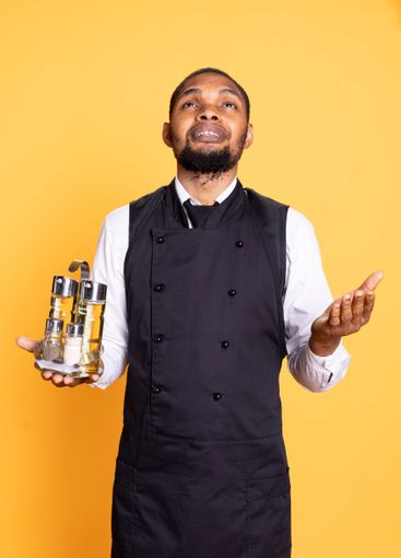 Restaurant staff in apron praying to Jesus against...