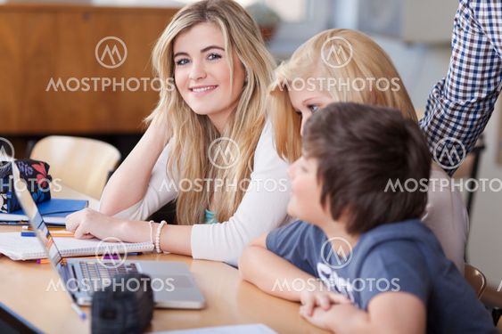 Female Students With Friends At Desk