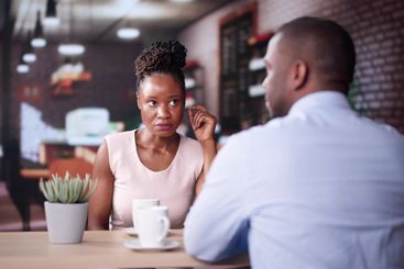 Laughing Male And Female Sitting In Cafe Drinking Coffee