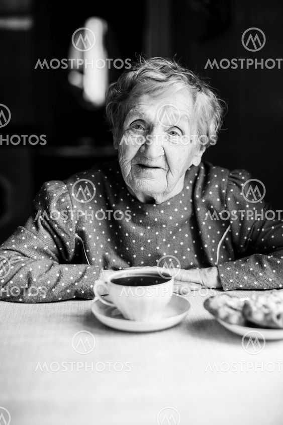 Portrait of an elderly woman with a Cup of tea. Black-and-white photo.