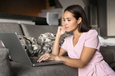 Focused woman websurfing information using modern laptop...