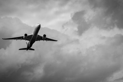 Commercial airplane on grey sky and clouds with copy...
