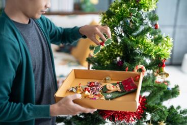 Happy hands Decorating Christmas tree for xmas holiday.