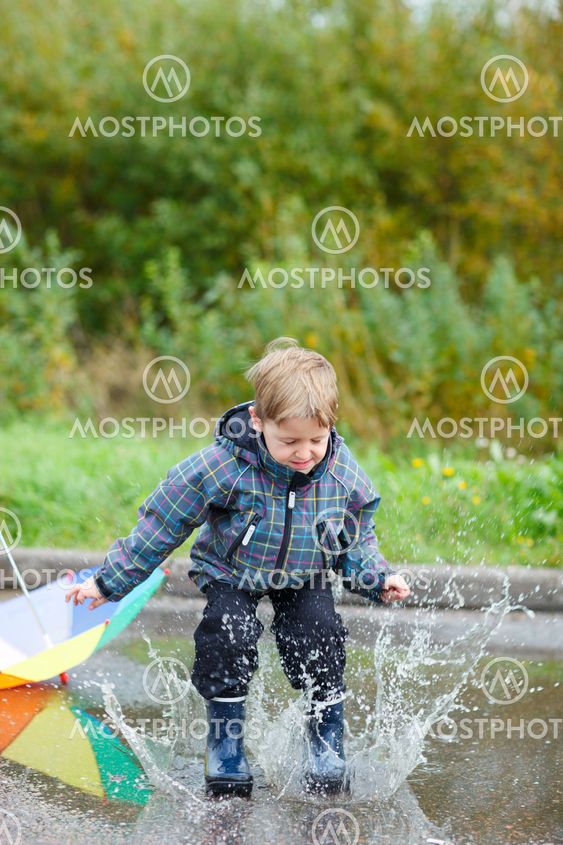 Boy jumping in puddle