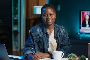 Portrait of smiling woman sitting on chair at home...