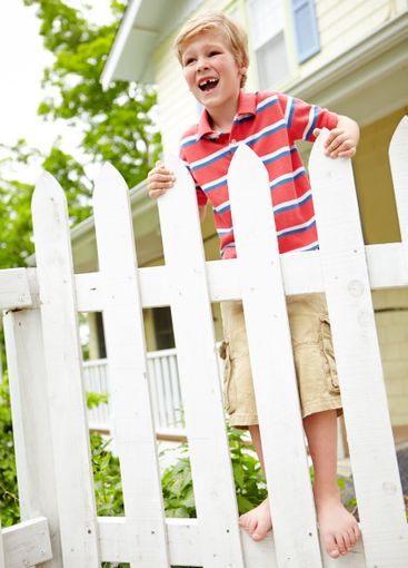 Happy child, fence and waiting with joy for holiday,...