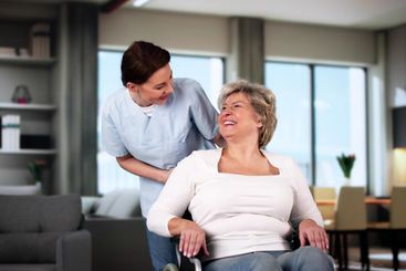 Smiling Caregiver Helping Older Patient