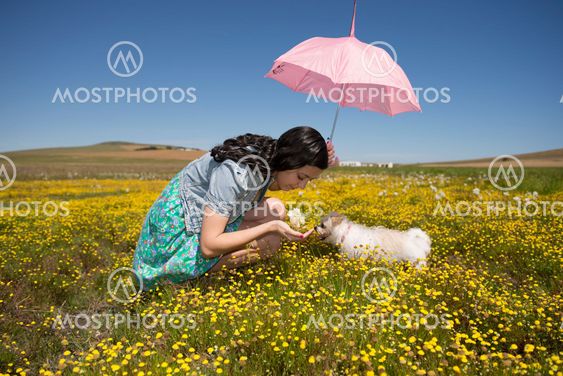 Beautiful adult smelling flowers on sunny field enjoying herself