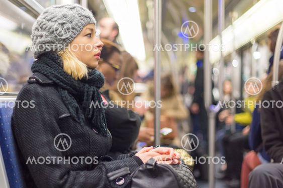 Woman traveling by subway full of people.