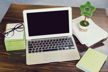Workstation setup with laptop, glasses, and decorative...