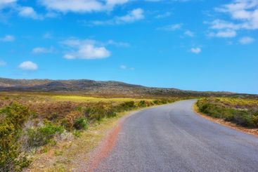 Road, blue sky and greenery with clouds for travel,...