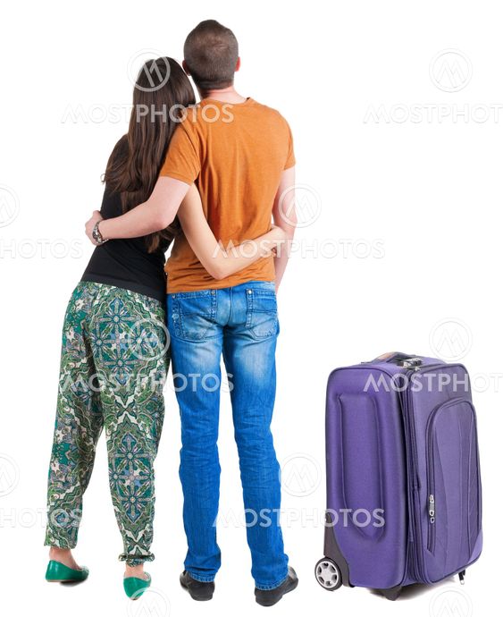 Back view of young couple traveling with suitcas .
