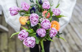 närbild på kvinna som håller bukett med tulpaner