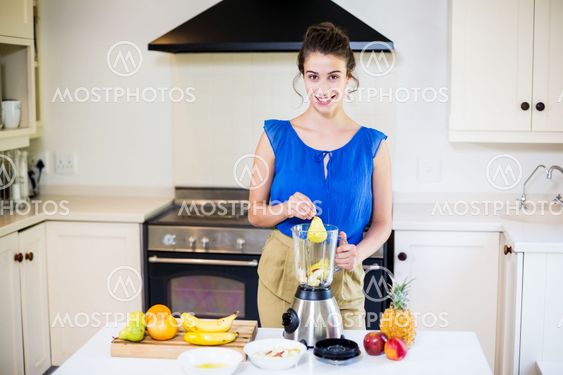Beautiful young woman preparing juice