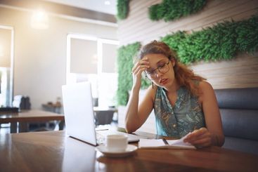 Woman, stress and reading notebook at cafe with deadline...