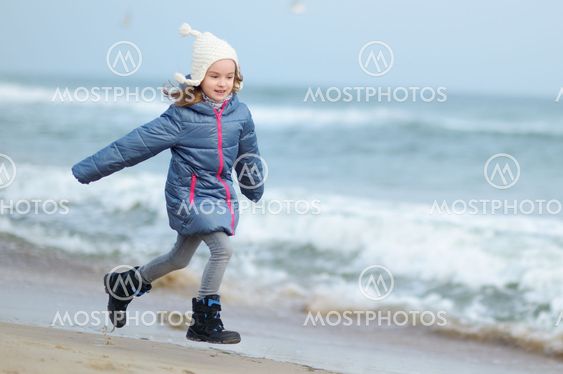 Adorable little girl playing by the ocean