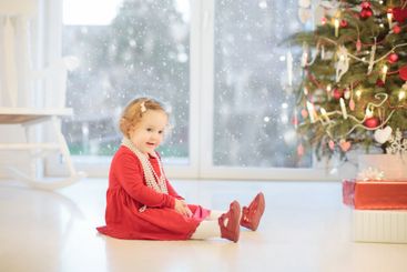 Child decorating Christmas tree. Kid on Xmas eve.