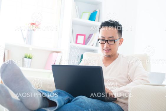 Asian male using internet at home