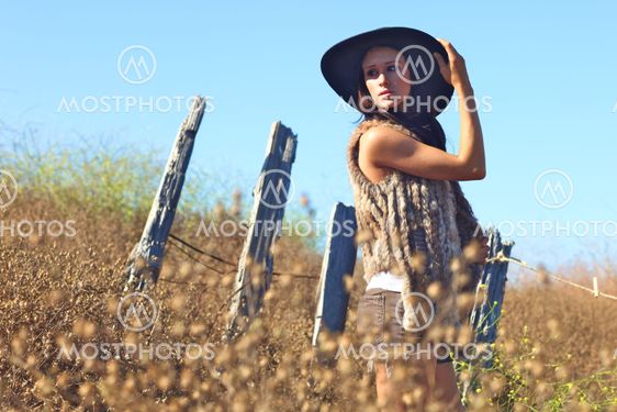 Young Beautiful Woman on a Field in Summer Time