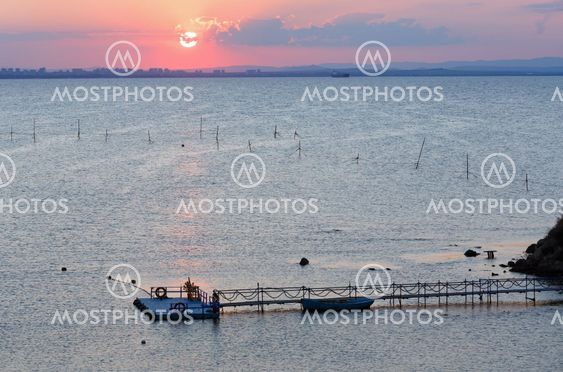 Sea sunset coast view with sun and pier.