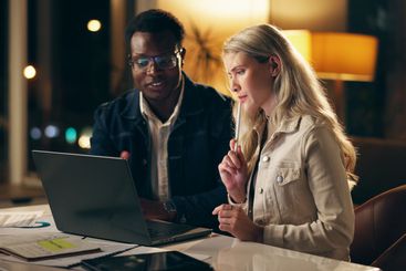 Laptop, teamwork and business people together at night...