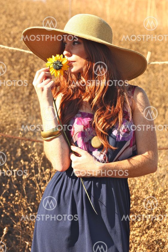 Young Beautiful Woman on a Field in Summer Time