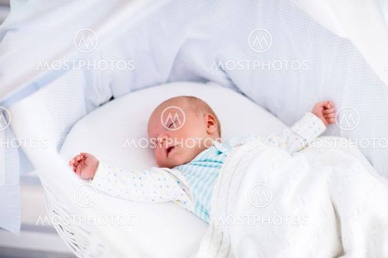 Cute newborn baby in white bed
