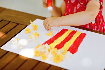 Little creative toddler girl painting with finger colors...