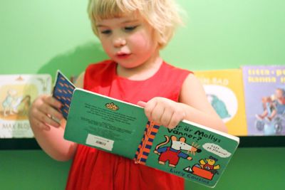 Liten flicka bläddrar i barnbok 3