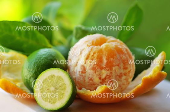 Peeled orange, and green lemons
