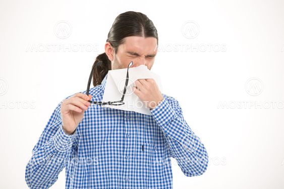 Young handsome man sneezing and using handkerchief