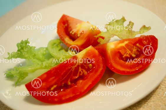 Slice tomatoes and lettuce on the white plate