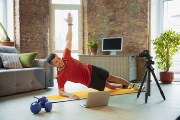 Young caucasian man training at home during quarantine...