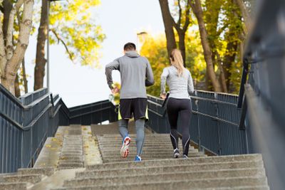 couple running upstairs in city park