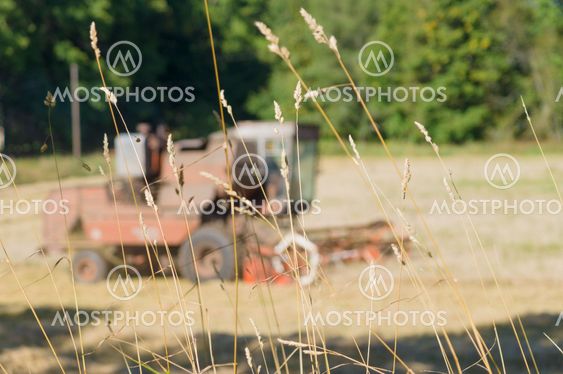Blurred image of combine harvesting through grass