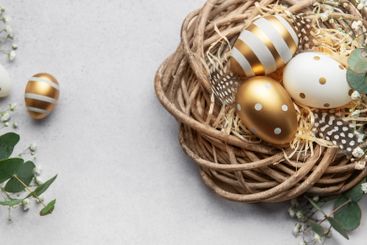 Easter eggs resting in a decorative nest with feathers...
