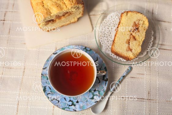 Teacup with slice of a delicious cake on a table