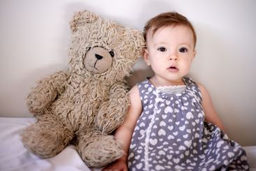Baby, girl and bed with teddy bear for playful...