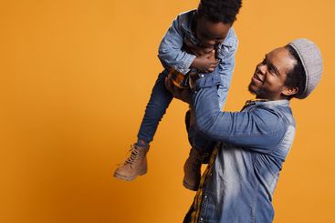 Affectionate loving father carrying his son and playing...